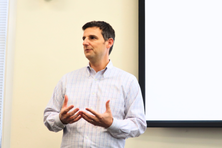 Jonathan Smith stands in front of project screen during his presentation